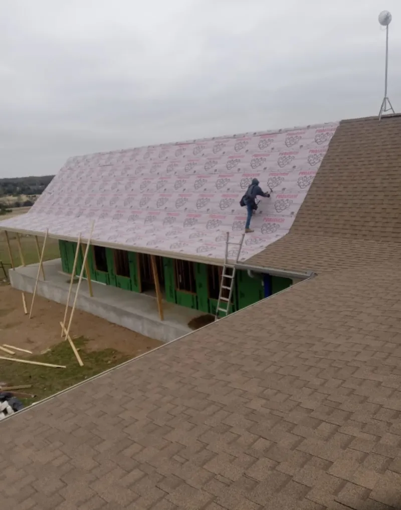 Worker preparing underlayment for a metal roof installation in Mountain View